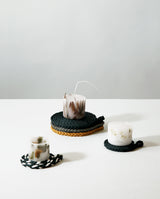 Made in Japan organic dried flower candles displayed gracefully on multi colors hand-braided coasters made with paracord