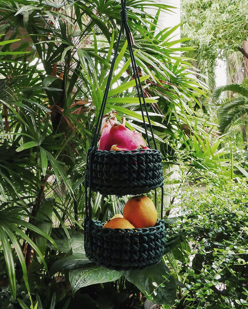 Dragon fruit and fresh oranges are placed inside "pinto" handing baskets in tropical home garden