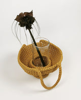 Aura bucket bag handcrafted with paracord in honey gold color holds clear cylinder glass vase with exotic bat flower freshly cut from home garden